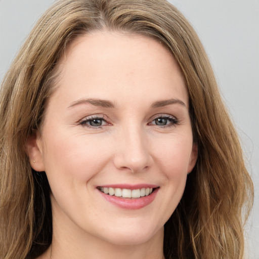 Joyful white young-adult female with long  brown hair and green eyes