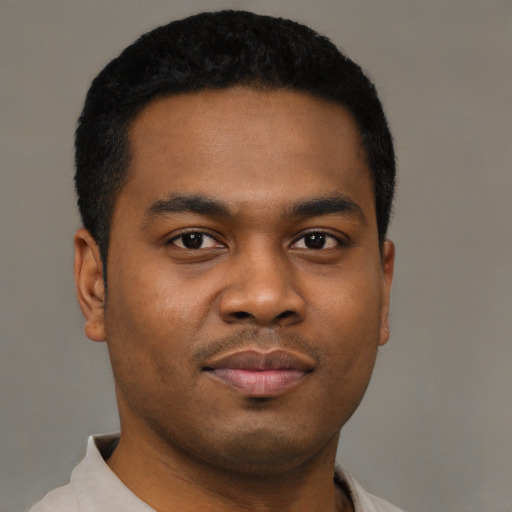 Joyful black young-adult male with short  black hair and brown eyes