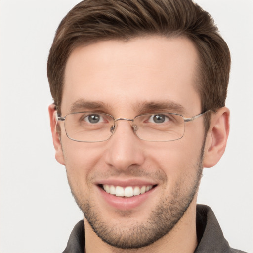 Joyful white young-adult male with short  brown hair and grey eyes