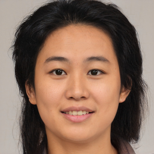 Joyful asian young-adult female with long  brown hair and brown eyes
