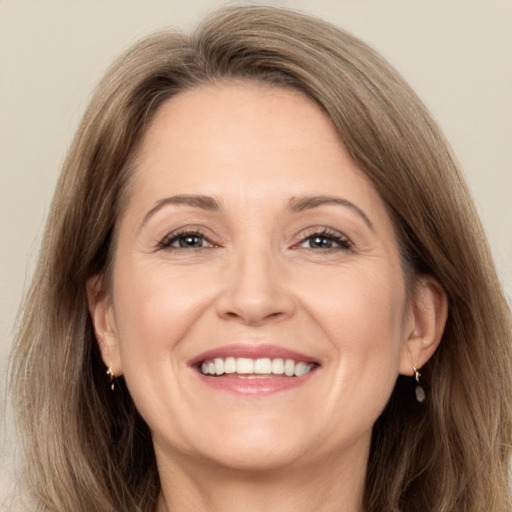 Joyful white adult female with long  brown hair and grey eyes