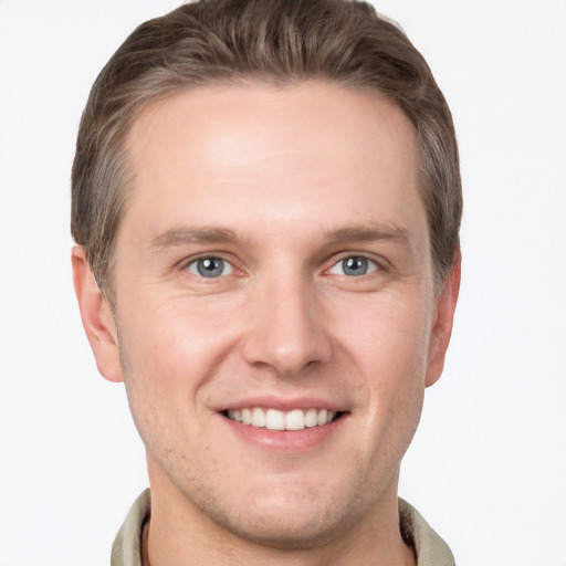 Joyful white young-adult male with short  brown hair and grey eyes