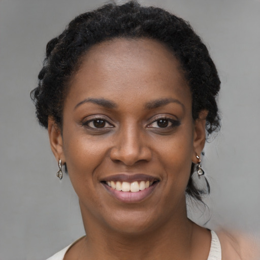 Joyful black young-adult female with short  brown hair and brown eyes