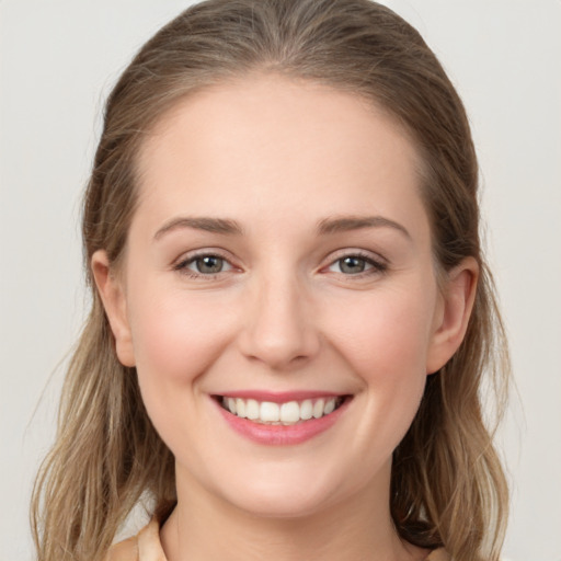 Joyful white young-adult female with medium  brown hair and grey eyes