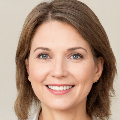 Joyful white young-adult female with medium  brown hair and green eyes