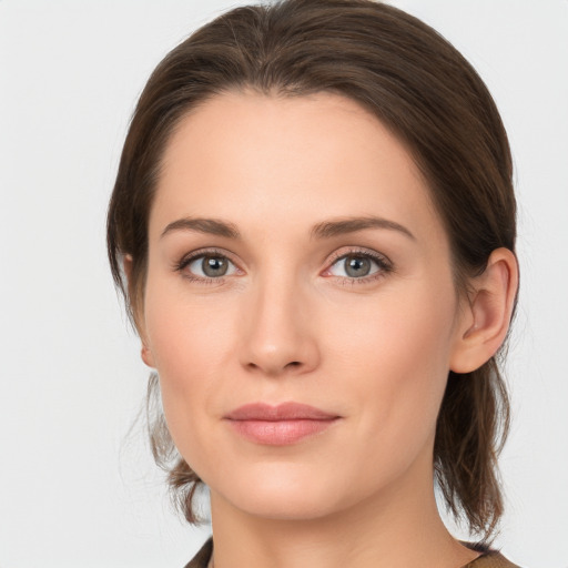 Joyful white young-adult female with medium  brown hair and grey eyes