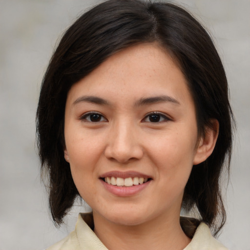 Joyful asian young-adult female with medium  brown hair and brown eyes