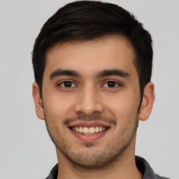 Joyful latino young-adult male with short  brown hair and brown eyes