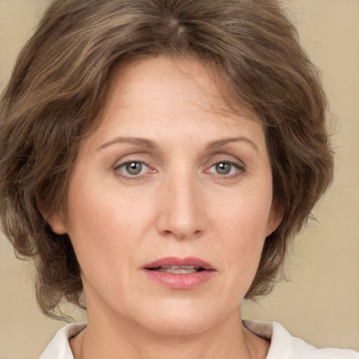 Joyful white adult female with medium  brown hair and green eyes