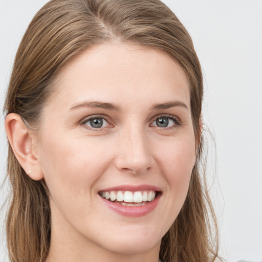 Joyful white young-adult female with long  brown hair and blue eyes