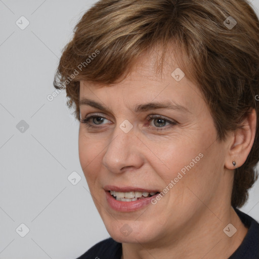 Joyful white adult female with medium  brown hair and brown eyes