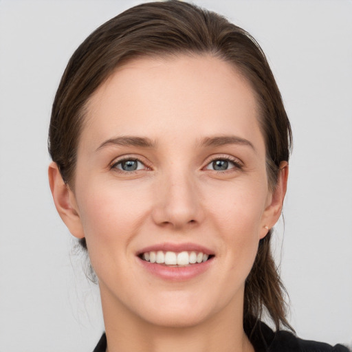 Joyful white young-adult female with medium  brown hair and grey eyes