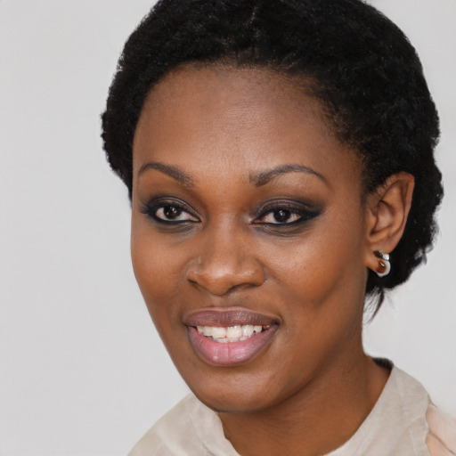 Joyful black young-adult female with short  black hair and brown eyes