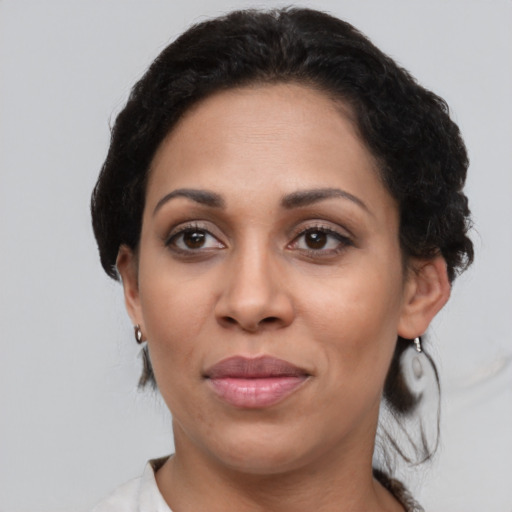Joyful latino adult female with short  black hair and brown eyes