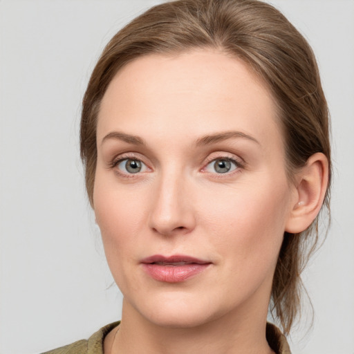 Joyful white young-adult female with medium  brown hair and blue eyes