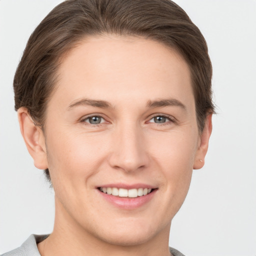 Joyful white young-adult female with short  brown hair and grey eyes