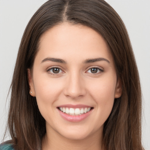 Joyful white young-adult female with long  brown hair and brown eyes