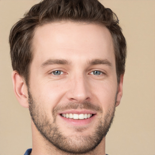 Joyful white young-adult male with short  brown hair and grey eyes