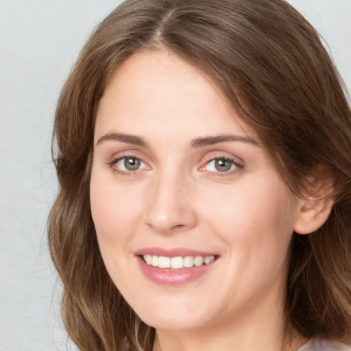 Joyful white young-adult female with long  brown hair and blue eyes