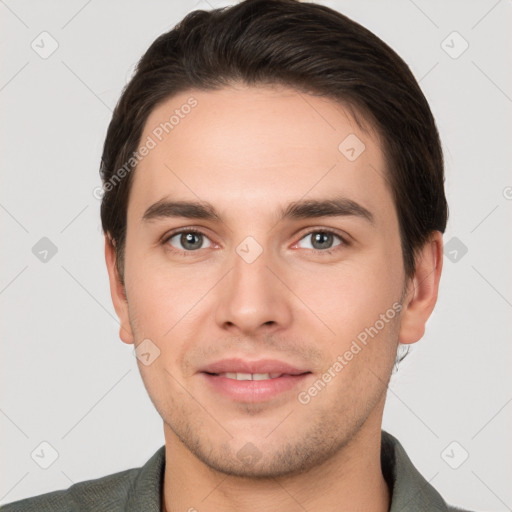 Joyful white young-adult male with short  brown hair and grey eyes