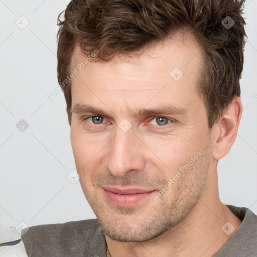 Joyful white adult male with short  brown hair and grey eyes