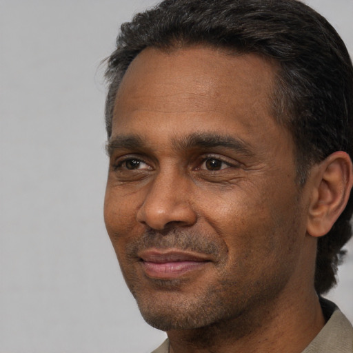 Joyful black adult male with short  black hair and brown eyes
