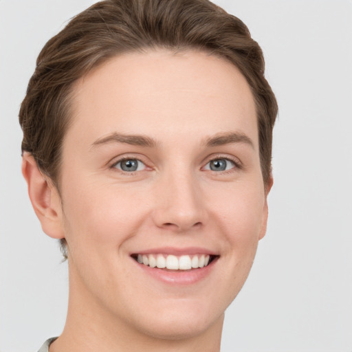 Joyful white young-adult female with short  brown hair and grey eyes