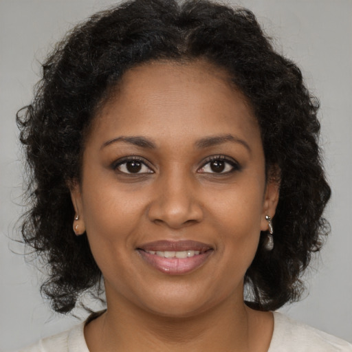 Joyful black young-adult female with medium  brown hair and brown eyes