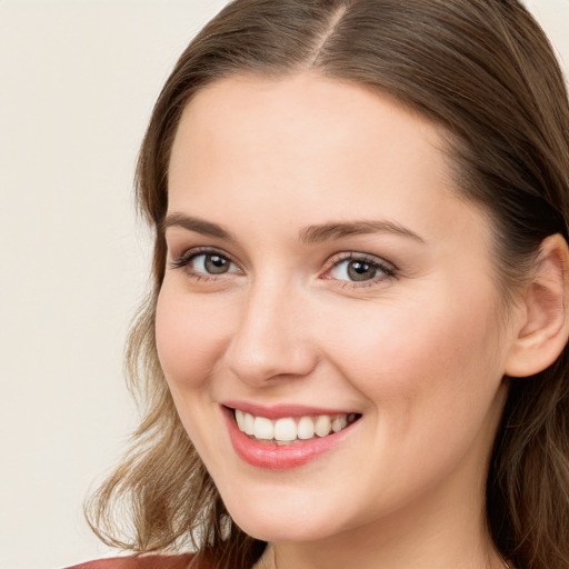 Joyful white young-adult female with long  brown hair and blue eyes