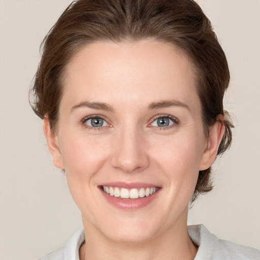 Joyful white young-adult female with medium  brown hair and grey eyes