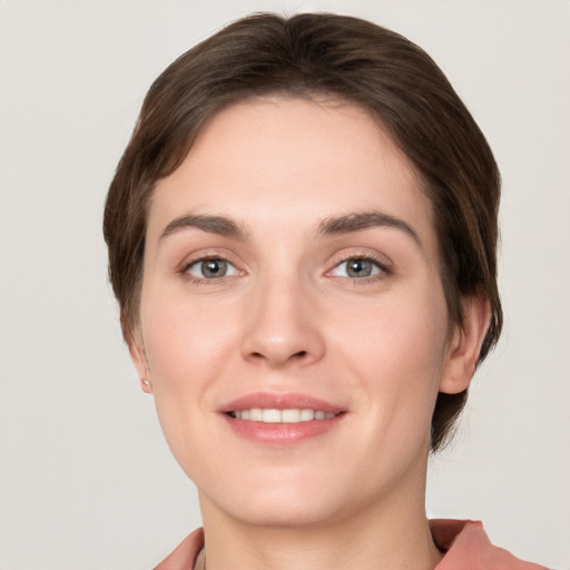 Joyful white young-adult female with short  brown hair and grey eyes