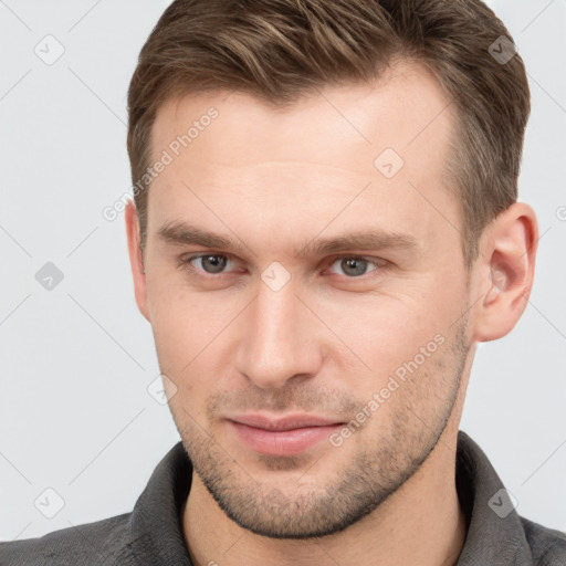 Joyful white young-adult male with short  brown hair and grey eyes