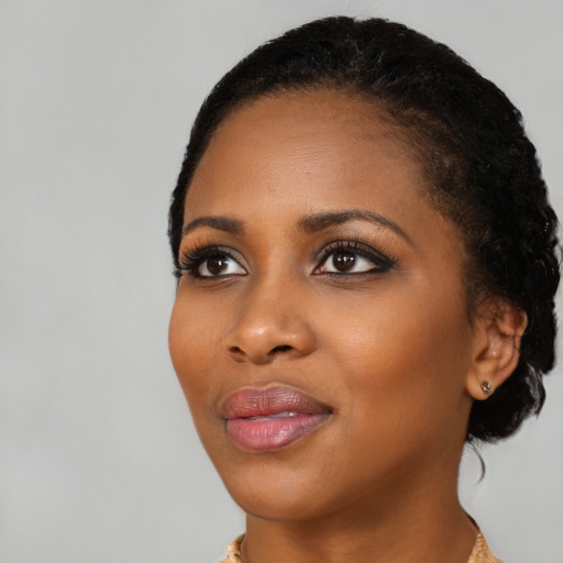 Joyful black young-adult female with short  black hair and brown eyes