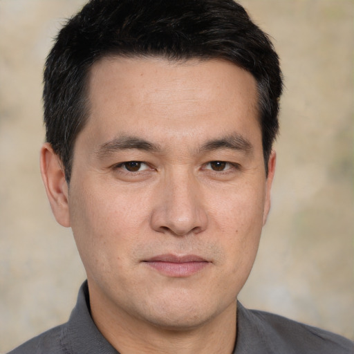 Joyful white adult male with short  black hair and brown eyes