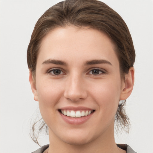 Joyful white young-adult female with short  brown hair and grey eyes