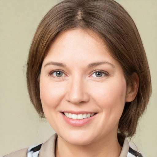 Joyful white young-adult female with medium  brown hair and grey eyes