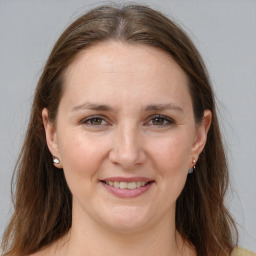 Joyful white adult female with long  brown hair and grey eyes