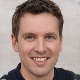 Joyful white adult male with short  brown hair and grey eyes