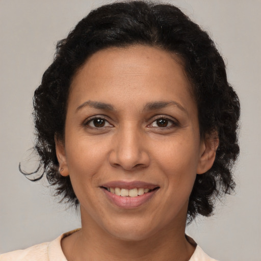 Joyful latino adult female with medium  brown hair and brown eyes