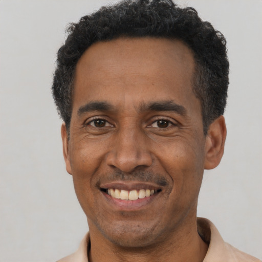 Joyful latino adult male with short  black hair and brown eyes
