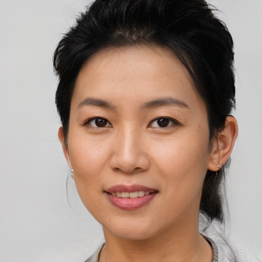 Joyful asian young-adult female with short  brown hair and brown eyes