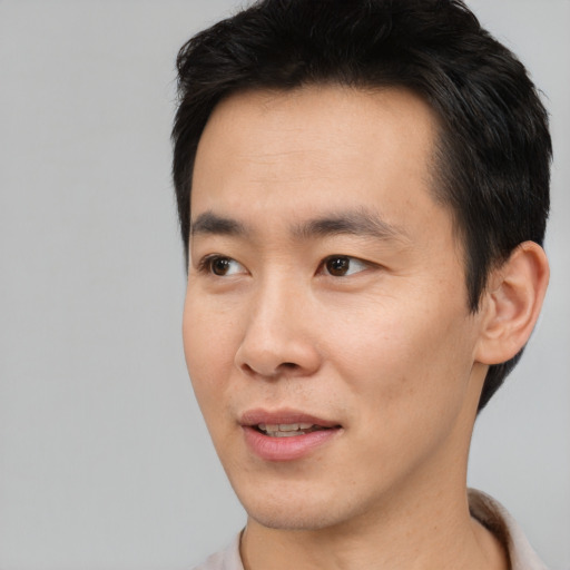 Joyful asian young-adult male with short  black hair and brown eyes