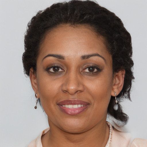Joyful black adult female with short  brown hair and brown eyes