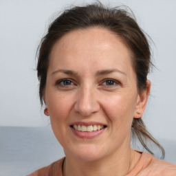 Joyful white adult female with medium  brown hair and brown eyes