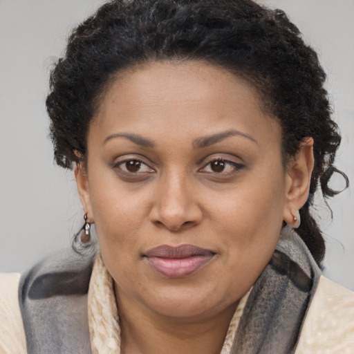 Joyful black adult female with long  brown hair and brown eyes