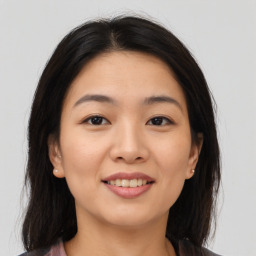 Joyful asian young-adult female with medium  brown hair and brown eyes