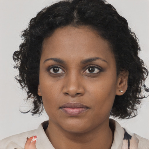 Joyful black young-adult female with long  black hair and brown eyes