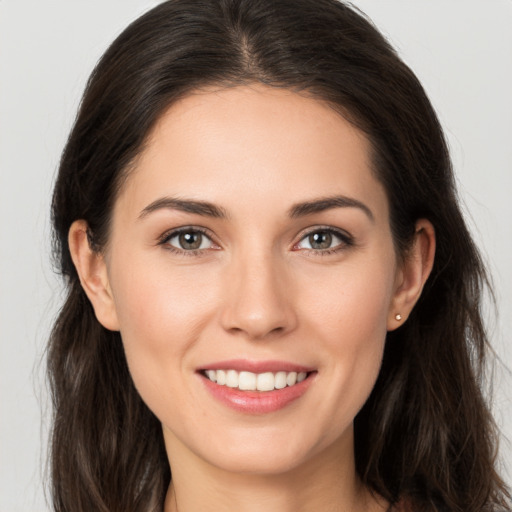 Joyful white young-adult female with long  brown hair and brown eyes