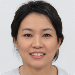 Joyful asian young-adult female with medium  brown hair and brown eyes