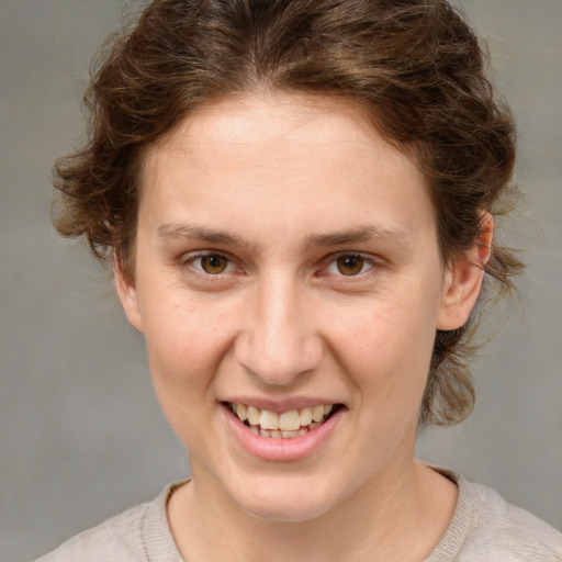 Joyful white young-adult female with medium  brown hair and green eyes